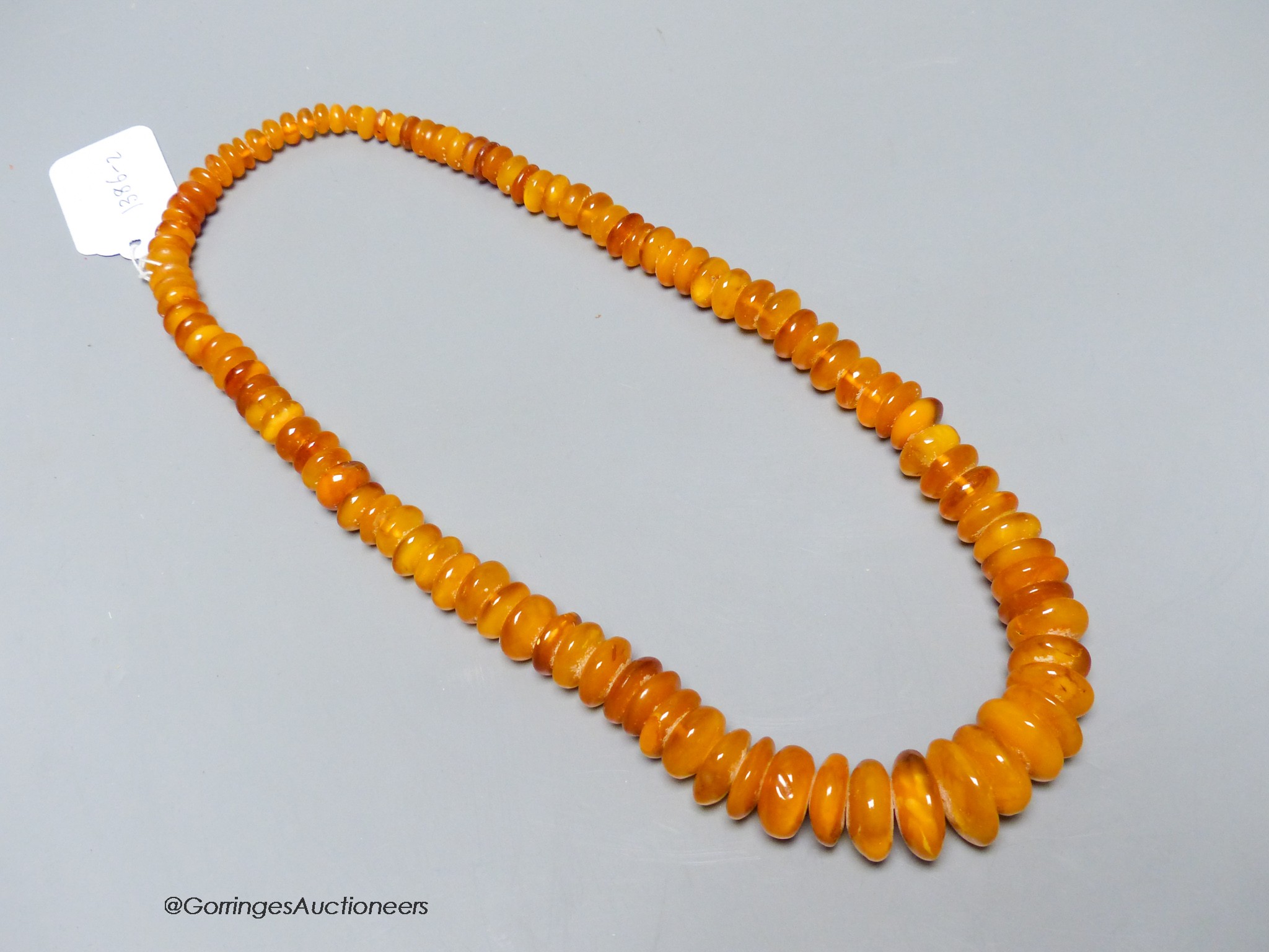 A single strand amber disc necklace, 67cm, gross weight 127 grams.